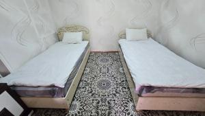 two beds sitting next to each other in a room at Sim-Sim Hostel in Panjakent