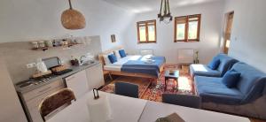 a living room with a blue couch and a table at Apartmani Jelenača in Sinanovići