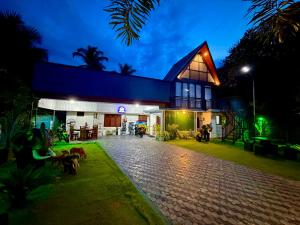 a house with dogs standing outside of it at night at Batti Lagoon Hotel in Batticaloa