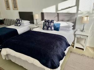 a bedroom with two beds with blue and white pillows at Karoo Velvet in Beaufort West