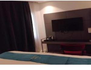a bedroom with a bed with a desk and a television at مساكن جدة in Jeddah