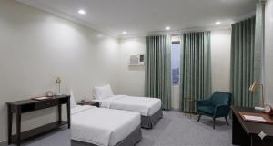 a hotel room with two beds and a desk and a chair at مساكن جدة in Jeddah
