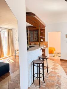 a kitchen and living room with a counter and stools at Apartamenty przy Starówce in Olsztyn