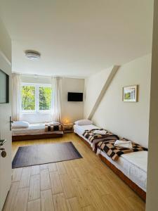 a living room with two beds and a window at Pokoje u Strażaka in Krościenko +24 photos