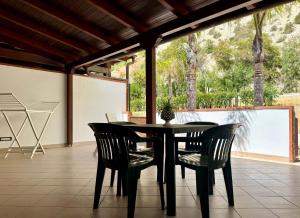 a black dining room table and chairs on a patio at Eraclea Minoa Village in Montallegro