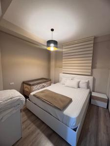 a bedroom with a large white bed and a lamp at Marina Bay Apartament 1 in Vlorë +22 photos