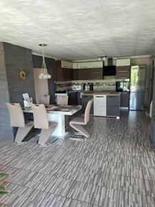 a kitchen with a dining table and chairs and a kitchen with at BÉTA Apartman in Sárospatak