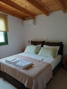 a bedroom with a large bed with green pillows at House by the sea in Aigio