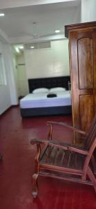 a room with a bed and a wooden bench in front of a bed at Aliya Stay in Galle