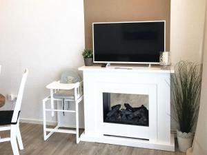 a living room with a tv on top of a fireplace at Mariehus in Wangerooge