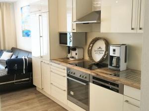 a kitchen with white cabinets and a stove top oven at Mariehus in Wangerooge