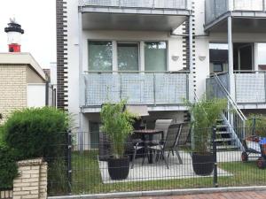 a fence with a table and chairs in front of a building at Mariehus in Wangerooge