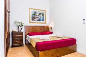 a bedroom with a large wooden bed with red pillows at Marco Polo Party Hostel in St. Julianʼs
