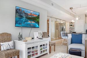 a living room with a tv on the wall at Dunes Club 2A by Pristine Properties Vacation Rentals in Cape San Blas