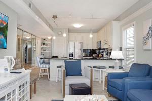 a kitchen and living room with blue chairs and a table at Dunes Club 2A by Pristine Properties Vacation Rentals in Cape San Blas