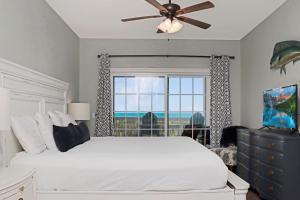 a bedroom with a bed with a ceiling fan and a window at Dunes Club 2A by Pristine Properties Vacation Rentals in Cape San Blas +62 photos
