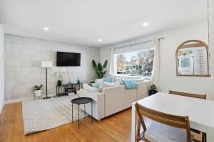 a living room with a white couch and a table at Bright & Fully Renovated Retreat - Holiday Home in Saskatoon