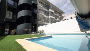 a swimming pool in front of a building at A Proa do Moliceiro - iConik Design Apartments in Aveiro