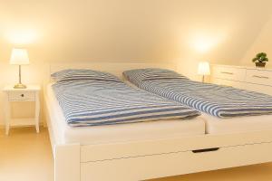 two beds with blue and white striped blankets at Kleine Auszeit Pellworm in Pellworm