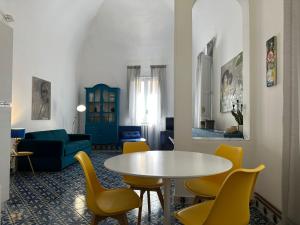 a living room with a table and yellow chairs at Suite LA BARONESSA in Lecce
