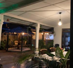 a patio with a table and chairs and an umbrella at Elephant Trail Homestay in Habarana