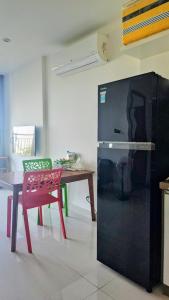 a kitchen with a table and a red chair and a refrigerator at TUỆ Home in Long Bình