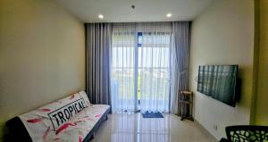 a living room with a couch and a sliding glass door at TUỆ Home in Long Bình