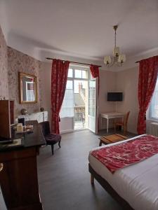 a hotel room with a bed and a desk at La Granitiere Maison de Charme in Saint-Vaast-la-Hougue