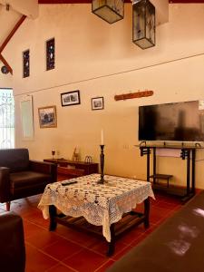 a living room with a table and a flat screen tv at The Baron House in Tupiza