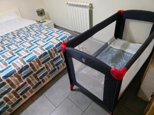 a black crib with red wheels next to a bed at Al Piccolo Cassaro in Caltanissetta