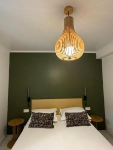a bedroom with a bed with a green wall and a chandelier at Kyrn Flor - Domaine Sant Antone in Corte