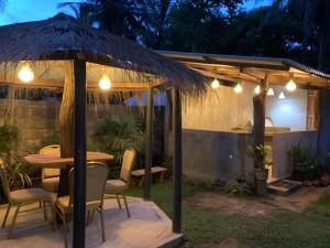 a patio with a table and chairs under a gazebo at Elephant Trail Homestay in Habarana