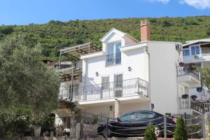 a black car parked in front of a white house at Villa Lime in Petrovac na Moru