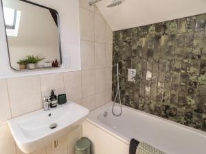 a bathroom with a sink and a tub and a mirror at Snowdrop Cottage in Morpeth +24 photos