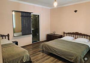 a bedroom with two beds and a mirror at Mountain Horizon in Borjomi