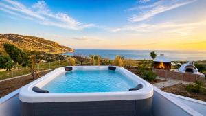 a hot tub on a balcony with a view of the ocean at Ardani paradise view villa with jacuzzi in Amoopi