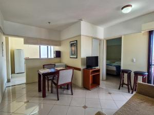 a living room with a table and a television at Apartment 116 - Jundiaí in Jundiaí
