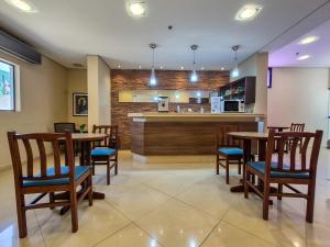 a restaurant with wooden tables and chairs and a counter at Apartment 116 - Jundiaí in Jundiaí