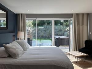 a bedroom with a large white bed and a balcony at Villa Le Touquet, piscine privée, 4 chambres in Le Touquet-Paris-Plage +16 photos