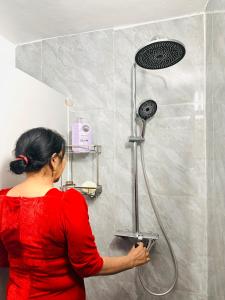a woman in a red shirt in a shower at Nhà trọ Lý Liêm in HÆ°ng YÃªn