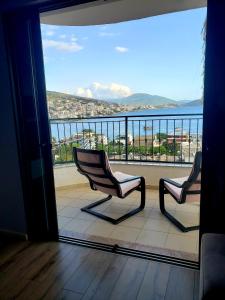 two chairs on a balcony with a view of the ocean at Panoramic Sea View Apartment Saranda in Sarandë +4 photos