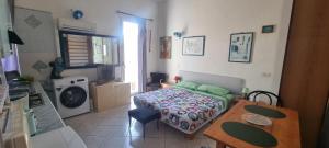 a bedroom with a bed and a table and a kitchen at Abbronzatissima Capo d'Orlando in Capo dʼOrlando