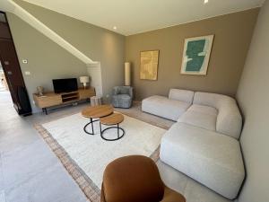 a living room with a couch and a table at Villa Le Touquet, piscine privée, 4 chambres in Le Touquet-Paris-Plage