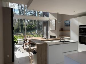 a kitchen with a table and a large window at Villa Le Touquet, piscine privée, 4 chambres in Le Touquet-Paris-Plage