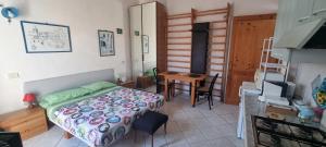 a bedroom with a bed and a table and a kitchen at Abbronzatissima Capo d'Orlando in Capo dʼOrlando