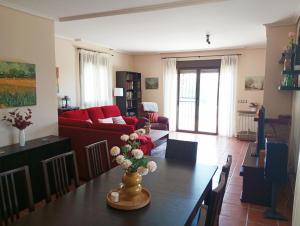 a living room with a table and a red couch at Chalet independiente con vistas in Bustarviejo