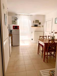 a kitchen and dining room with a table and a refrigerator at CiroMenotti62 in Marina di Carrara