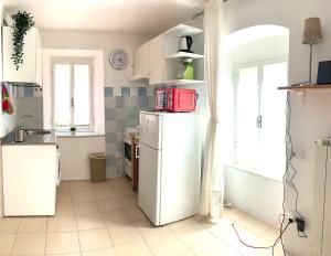 a kitchen with a white refrigerator and a window at CiroMenotti62 in Marina di Carrara