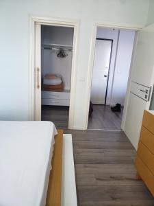 a room with a hallway with a bed and a closet at Panoramic Sea View Apartment Saranda in Sarandë