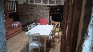 a living room with a table and chairs at Casa O Castelo en Touro in Touro